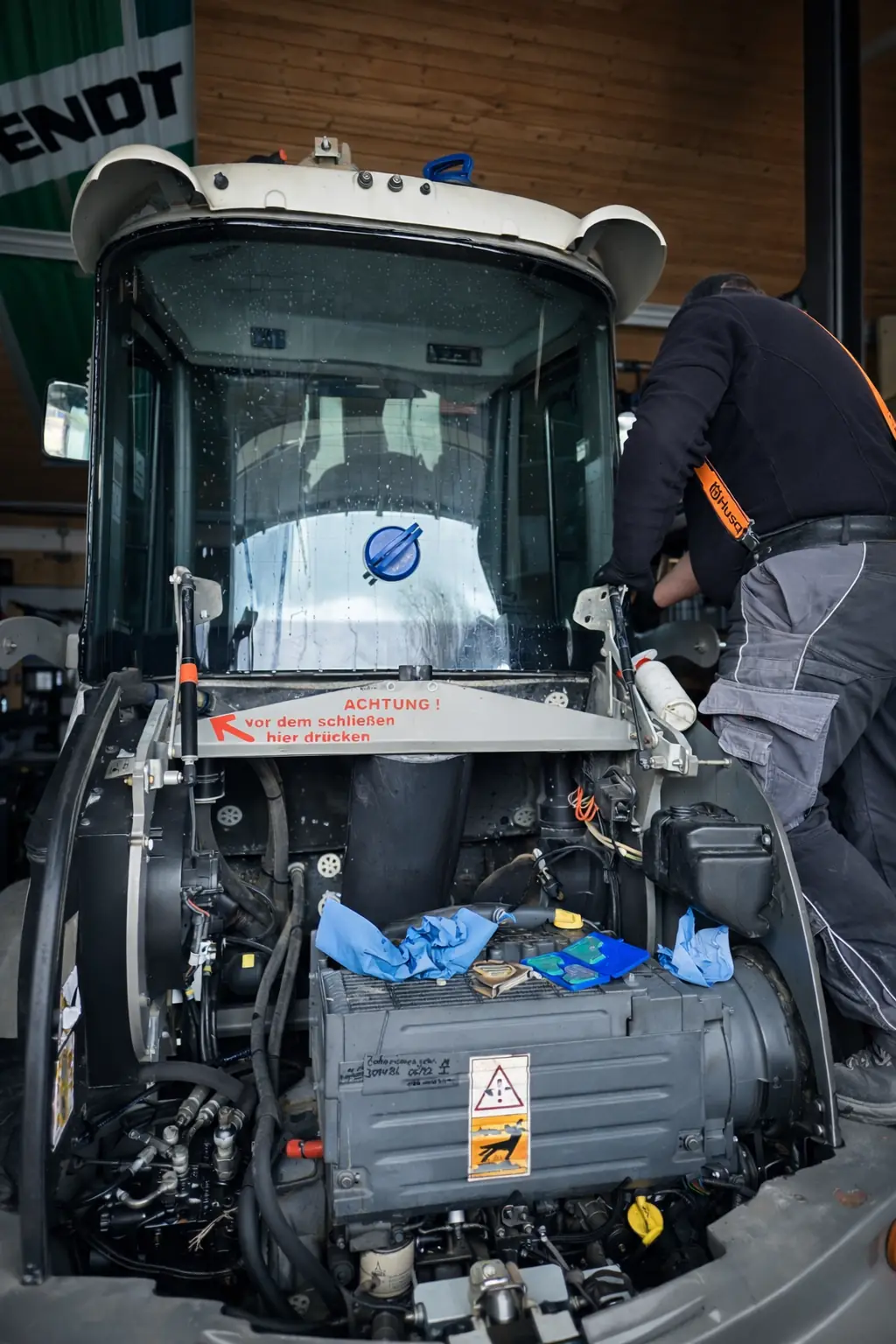 Angehobene Fahrerkabine eines Fendt-Schleppers in der Werkstatt, Arbeit am offenen Motorraum